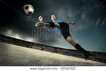 fodboldspiller på fodboldbanen af stadion med drammatic sky