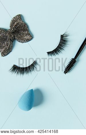 Creative Layout With Eyelashes And Make Up Ccessories. Closed Eyes On Pastel Blue Background