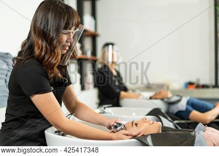 Asian Young Beautiful Woman Customer Lying Down On Salon Washing Bed Getting Hair Washed In Hair Sal