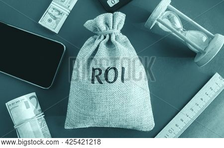 Money Bag With The Word Roi. Return On Investment Concept. Profitability And Loss-making Of Investme