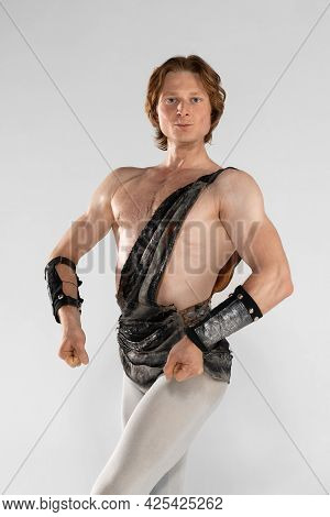 Spectacular Man. Young Male Ballet Dancer In Ancient Rome Costum Posing At Blue Studio As Historical
