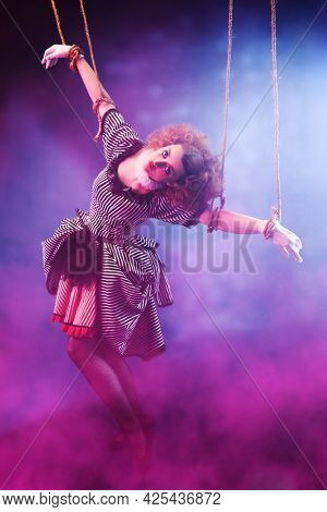 Puppet theater and circus. The actress plays a doll on strings at a performance in a puppet theater. Full length portrait in vintage style.