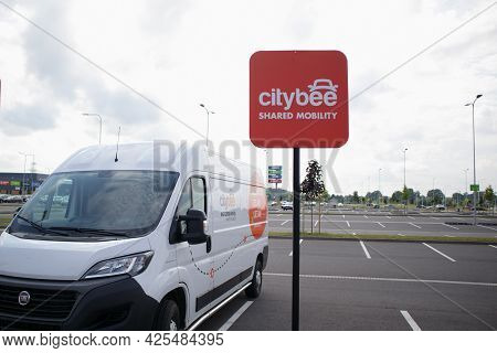 The Citybee Carsharing Minibus Is Parked In The Parking Lot Of A Large Supermarket. Riga, Latvia - 2