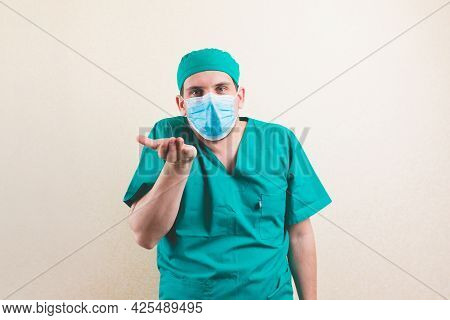 Asking Doctor In Green Surgeon Suit And Protective Breathing Mask With Nothing In His Hand On The Ye