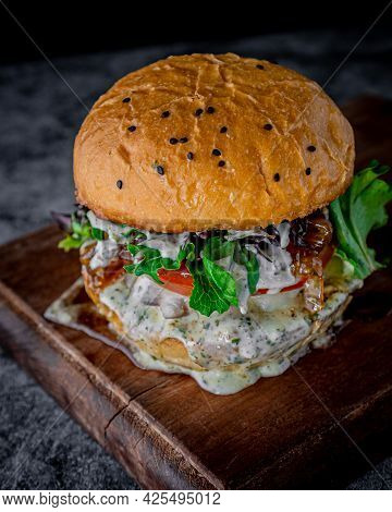 Large Blue Cheese Burger With Bacon, Jack Cheese, Arugula, Tomato And Caramelized Onion Served On A 