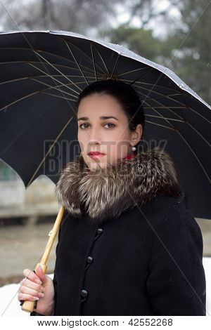Retrato de la hermosa joven con un paraguas