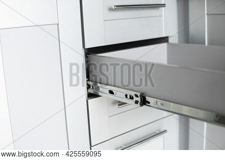 Stainless Telescopic Bayonet Drawer Slide Guides, Installed On A Kitchen Cabinet From Gray Chipboard