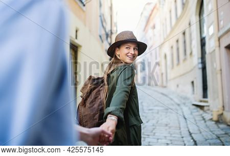 Young Couple Travelers In Love Sightseeing In City On Holiday, Holding Hands When Walking.