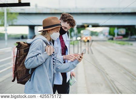Young Couple Tourist Travelers On Holiday Using Smartphone In City, Coronavirus Concept.