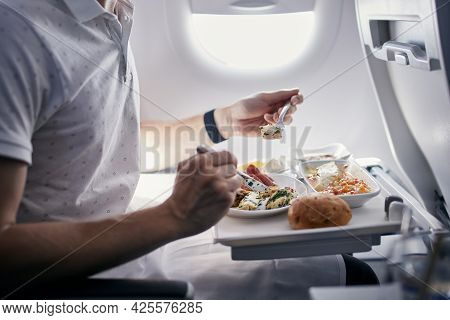 Passenger Eating Airline Meal. Menu In Business Class On Medium Haul Flight.
