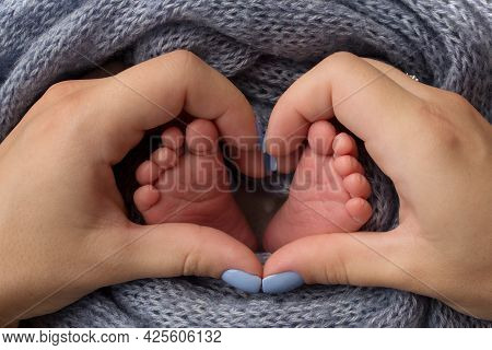 Feet Of A Newborn Close-up In A Woolen Blanket. Pregnancy, Motherhood, Preparation And Expectation O