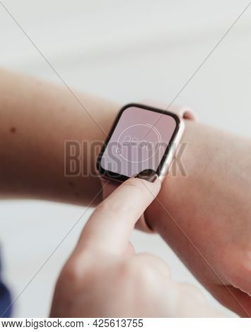 Woman looking at the time on her digital smartwatch mockup
