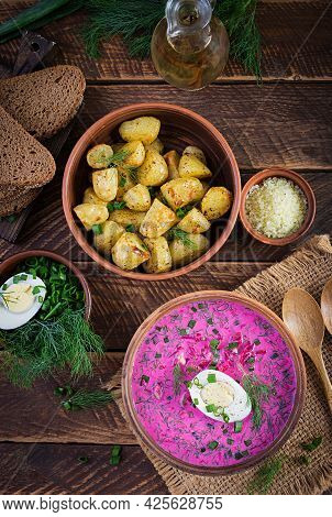 Cold Borscht, Summer Beet Soup With Fresh Cucumber,  Boiled Egg And Baked Potatoes On Wooden Table. 