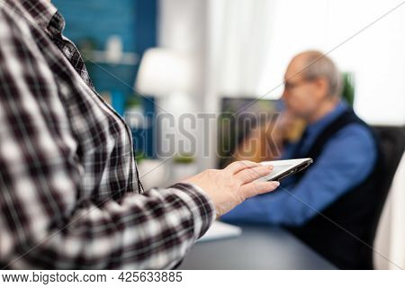 Close Up Of Senior Woman Hand Scrolling On Digital Device In Home. Close Up Of Elderly Woman Using M