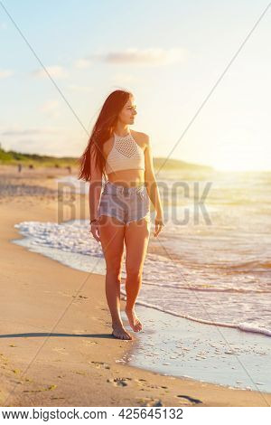 Lonely Young Woman Walking On The Beachsunset Day.beach Woman In Fashion Beachwear Relaxing Walking 
