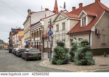 Latvia, Cesis, August, 2020 - Old Restored Wooden Houses Under Red Roof Tiles In The Narrow Streets 