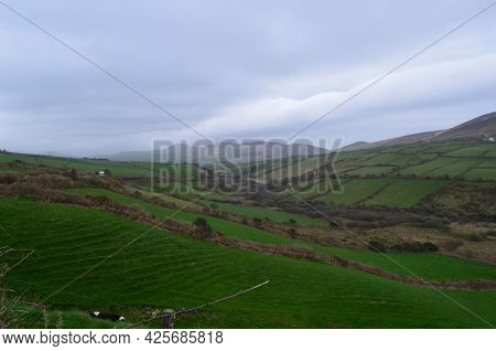 Rolling Lush Green Grass Fields And Hills In Dingle Ireland.