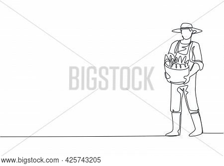 Continuous One Line Drawing Young Male Farmer Carrying A Basket Full Of Fruit With His Hands In Fron