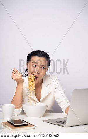 Asian Woman Working Hard Overtime Eating Instant Noodles At Office.
