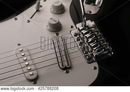 Black And White Electronic Guitar Close Up View. Details Of Rock Guitar. Strings, Tremolo And Volume