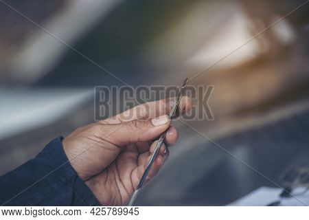 Car Mechanic Man Hand Checking Dipstick Engine Oil Car Mechanical On Site Service. Close Up Hand Man