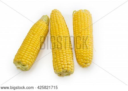 Raw Ears Of The Freshly Picked Sweet Young Corn With Peeled Green Husks On A White Background