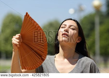 Stressed Asian Woman Fanning Suffering Heatstroke In The Street A Warm Summer Day