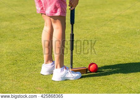 Female Croquet Player Hitting The Ball With Mallet
