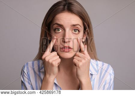 Woman Checking Her Health Condition On Grey Background. Yellow Eyes As Symptom Of Problems With Live