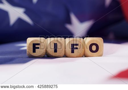 American Economy And Business Concept. The Us Flag Has Cubes With The Inscription - Fifo