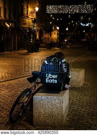 Strasbourg, France - Nov 29, 2019: Lonely Uber Eats App Driver Delivery Young Man Sitting On The Sto