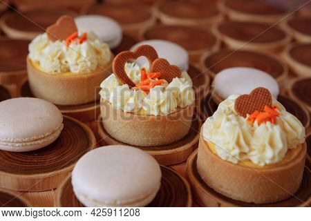 White Delicate Lowly Macaroons On A Wooden Background. The Pastel Tone Of The Cream Inside The Frenc