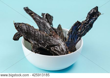 Training Treats For Pets On Blue Background. Natural Air Dried Dog Treats In A White Ceramic Bowl. T