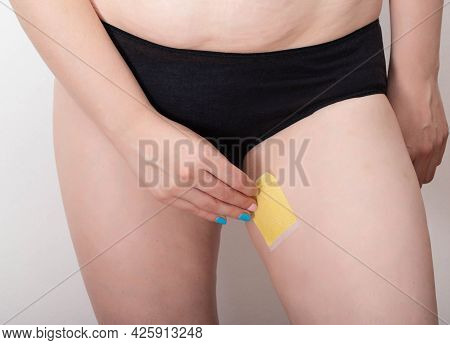 The Girl Sticks A Fat-burning Plaster On Her Legs In The Thigh Area For Skin Elasticity And Cellulit