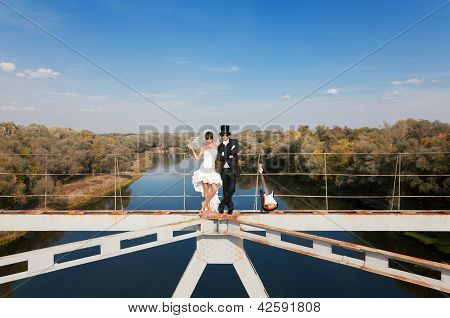 Bride And Groom On Bridge Over The River