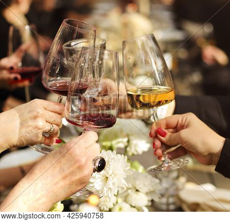 Group Of Crop Anonymous Friends Clinking Glasses With Wine While Gathering Around Table With Delicio