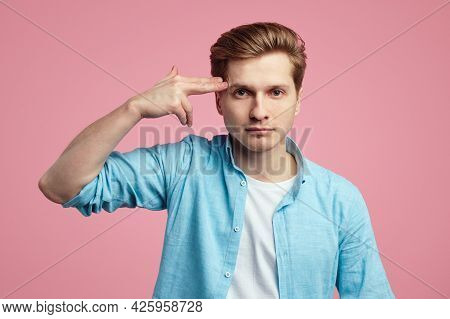 Serious Tired Attractive Guy Shoots In Temple With Finger, Demonstrates Suicide Gesture, Wears Blue 