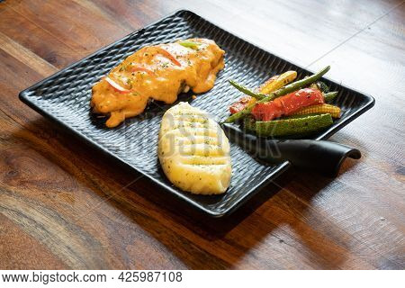 Three Quaters Shot Of Asthetic Modern Plate In Black Covered With Snack Of Mashed Potatoes Chili Sal