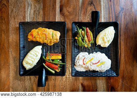 Flatlay Shot Showing Two Asthetic Black Square Plate With Handle Placed On Wooden Table Filled With 