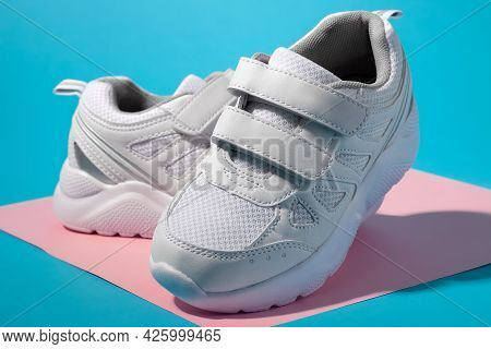 Macro Side View Of Two White Kid Sneakers With Velcro Fasteners For Comfortable Footwear On A Geomet