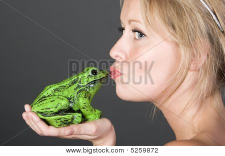Shot Of A Pretty Blonde Girl Kissing A Frog