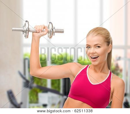 fintess, healthcare and dieting concept - young sporty woman with heavy steel dumbbell