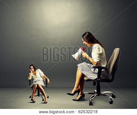 big angry woman screaming at lazy woman over dark background