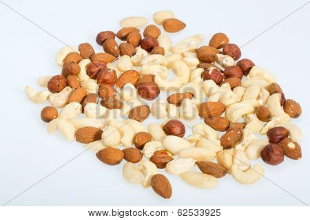 mixed nuts - hazelnuts walnuts cashews pine nuts isolated on white background