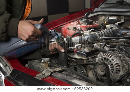 Auto repairman pouring antifreeze into radiator