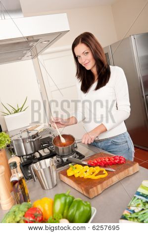 junge Lächelnde Frau in der Küche kochen