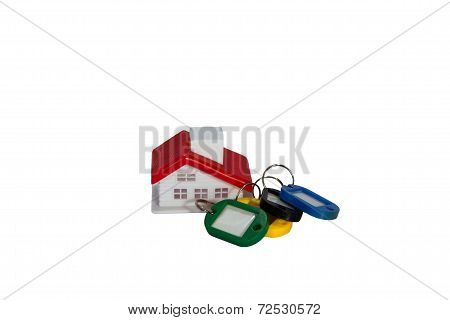 Small red roof and keys ring on white background.