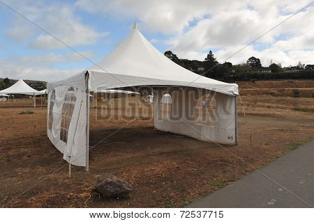 White Tents In A Dry Field Outdoors