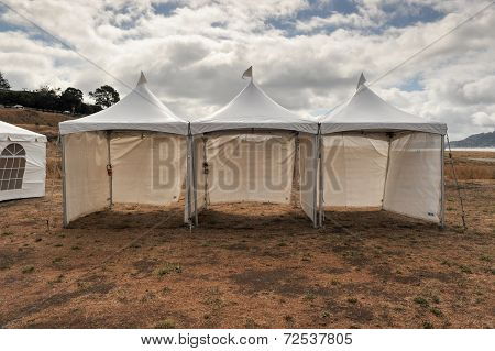 White Tents In A Dry Field Outdoors