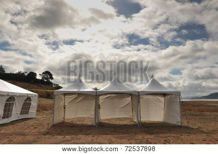 White Tents In A Dry Field Outdoors